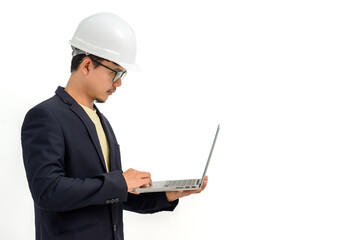 Portrait of Asian male architect or engineer wearing white hard hat holding laptop isolated on white background Copy space over a white studio background.