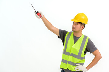 Asian male construction worker wearing hard hat holding construction walkie talkie isolated on white background Copy space over a white studio background.