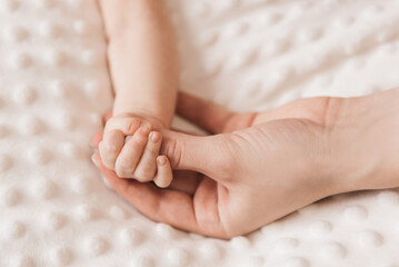 A small child's hand in the mother's hand