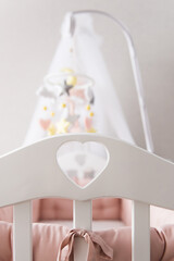 Toys over the crib. A mobile baby cot with stars, clouds and a unicorn.