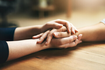 Holding hands, comfort and support of friends, care and empathy together on table in home mockup. Kindness, love and women hold hand for hope, trust or prayer, solidarity or compassion, help or unity - Powered by Adobe