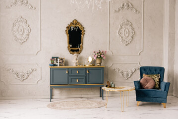 Luxurious interior with vintage chest of drawers, gold mirror, armchair and stucco walls, epoxy resin table