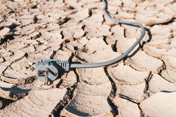 Electricity plug on  the land with dry cracks