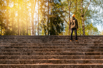 Man standing on the concrete stairs and looking to the forest trees
