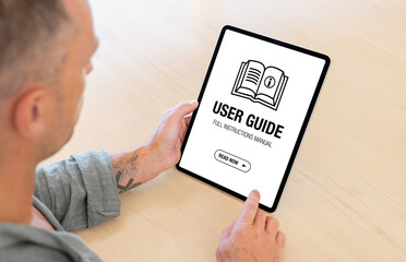Man reading user guide document on digital tablet