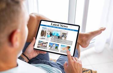 Fototapeta na wymiar Man reading news website on digital tablet