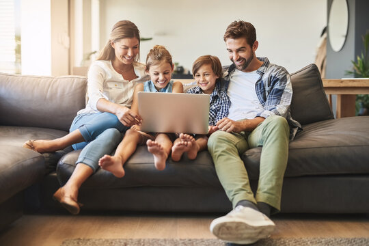 Family, laptop and kids with parents on a living room sofa with education game online. Mom, dad and young children together with bonding, parent care and love in a house watching a video on computer