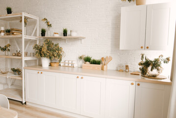 Fototapeta na wymiar Kitchen white wooden kitchen with Scandinavian-style dining area decorated with mimosa