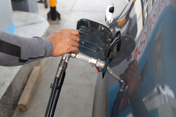 Close up hand of man pumping CNG gas in car at gas station