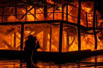 silhouette of a Fireman dousing flames
