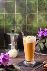 Cold coffee with ice cream in a glass goblet on a wooden background. Coffee recipes.