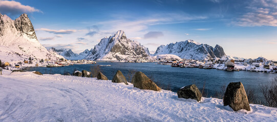 Amazing winter seascape.  North fjord and rocky mountains in winter at sunny day. Reine Village, Lofoten Islands, Norway