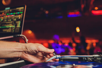 DJ playing vinyl musical record at hip hop party,festival.Concert in the nightclub.Professional...