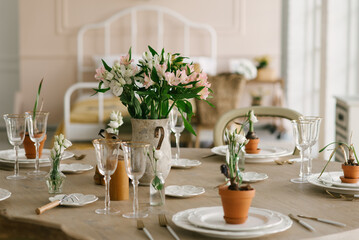 Dining table with beautiful setting, glasses and fresh flowers