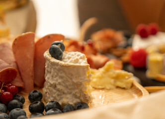 Assorted snacks on a black stone plate on a restaurant table on a window background