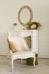 Vintage armchair on the background of a white fireplace and mirror