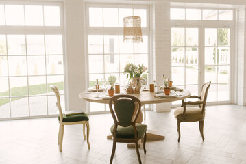 Dining table with vintage chairs with beautiful setting, glasses and fresh flowers