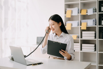 Happy asian business woman have the joy of talking on the smartphone, tablet and laptopon the  office .