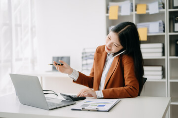 Happy asian business woman have the joy of talking on the smartphone, tablet and laptopon the  office .