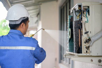 Rear view of male air conditioner technician, repair service, installation of air conditioner in the house Are going to repair and take care of filling air conditioners in homes and buildings.