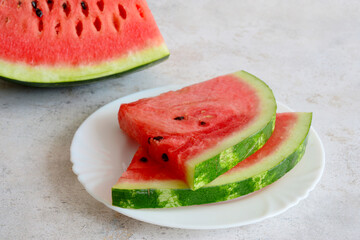 A plate of watermelon slices on a table isolated, close up 