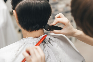 the hairdresser straightens the girl's hair after a short haircut