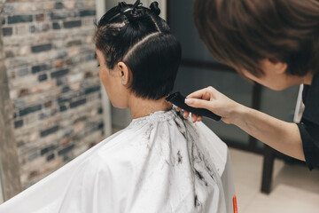 the hairdresser straightens the girl's hair after a short haircut