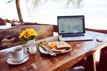 Laptop, travel or empty table at cafe for remote workspace in the morning with connection. Background, internet or seaside view coffee shop for digital blog online with brunch meal, tea or food
