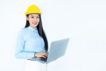 Asian woman architect or construction engineer wear yellow hardhat on white background.Young asian architect woman smiling happy.Asian woman architect looking and using at laptop. Industry concept.