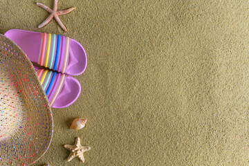 Hat, flip flops and shells on the beach. Beautiful summer still life.
