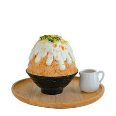 Japanese shaved ice dessert , milk tea kakigori bingsu topped with sweet whipping cream almond stick Thai tea sauce condensed milk on table in cafe. Traditional summer dessert menu in Japan.