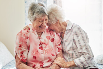 Happy, funny and senior woman friends laughing in the bedroom of a retirement home together. Smile,...
