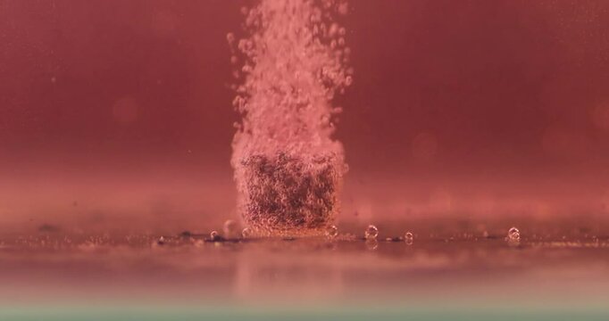 small sugar candy cube dissolves in red cold water, concept video to show that time is fading away, 2k and 120fps.