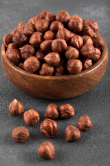 View of a bowl full of hazelnuts on a black background
