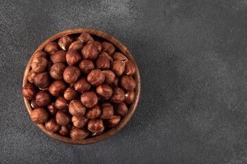 View of a bowl full of hazelnuts on a black background