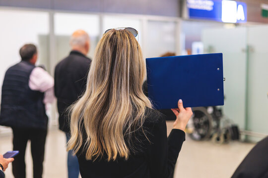 Meeting at the airport, person holding a placard card sign with welcome title text, greeting passenger on arrival, holding a name plate to receive a traveler, arrival area at international terminal