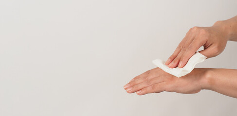 The hand is holding tissue paper and wipes on white background.