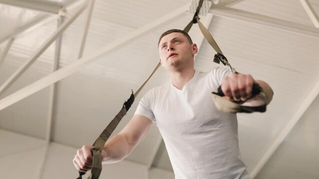 A young male gym-goer works out on a weight lifting machine, targeting his chest and arms to build muscle mass. gay Fitness isn't just a hobby, it's a way of life in gym