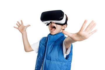Excited little kid wearing modern goggles of virtual reality on bright white backdrop. Boy screaming.