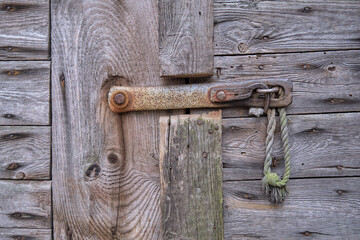 Old wooden door closed with a hook.