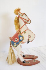 Leather Novelty Toy Horse with Red and Blue Saddle on White Background