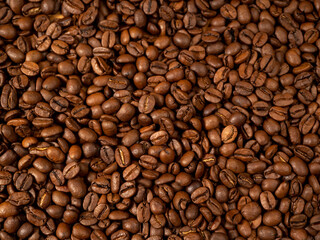 Fototapeta premium Background from roasted coffee beans. Scattered coffee beans. Coffee beans close up.