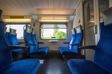 Passenger train with empty seats. Wide-angle long exposure, blurry green background out the window of an empty train in Switzerland, Europe, no people