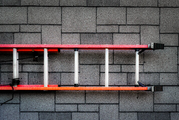 An aluminum ladder is hung on the side of this garage in Upstate NY.