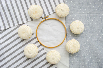 Meringue homemade zephyr marshmallows with round embroidery hoop frame on cotton tablecloth. Mockup card. Template for recipes, food menu, craft
