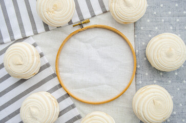 Meringue homemade zephyr marshmallows with round embroidery hoop frame on cotton tablecloth. Mockup...