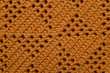 Orange crochet mesh fabric with triangle pattern. Knitted background.