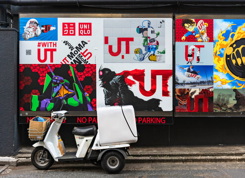 tokyo, harajuku - may 10 2023: Japanese Honda Gyro three-wheeled motorcycle illegally parked in front of a wall with advertise posters featuring japanese anime characters in collaboration with uniqlo.