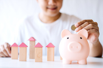 Bank loan for building houses, young man saving money in a piggy bank to plan a condo purchase