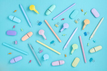 School pastel colors supplies. Stationery on pastel mint green background. Highlighter in the form of shells. Flat lay.